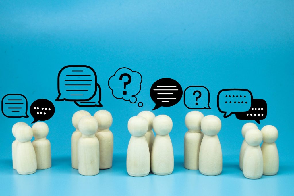 Wooden figures with chat icons representing Mocean Web Portal for Malaysian business owners and marketers to send SMS campaigns easily.