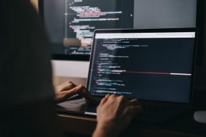 Developer coding on a laptop, integrating Mocean SMS API for secure and scalable messaging in Malaysia.